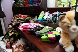 a dislpay of colorful, patterned socks, stuffed animals and hand-made slippers at Andrea's Red Dress, clothing boutique in Eugene, Oregon